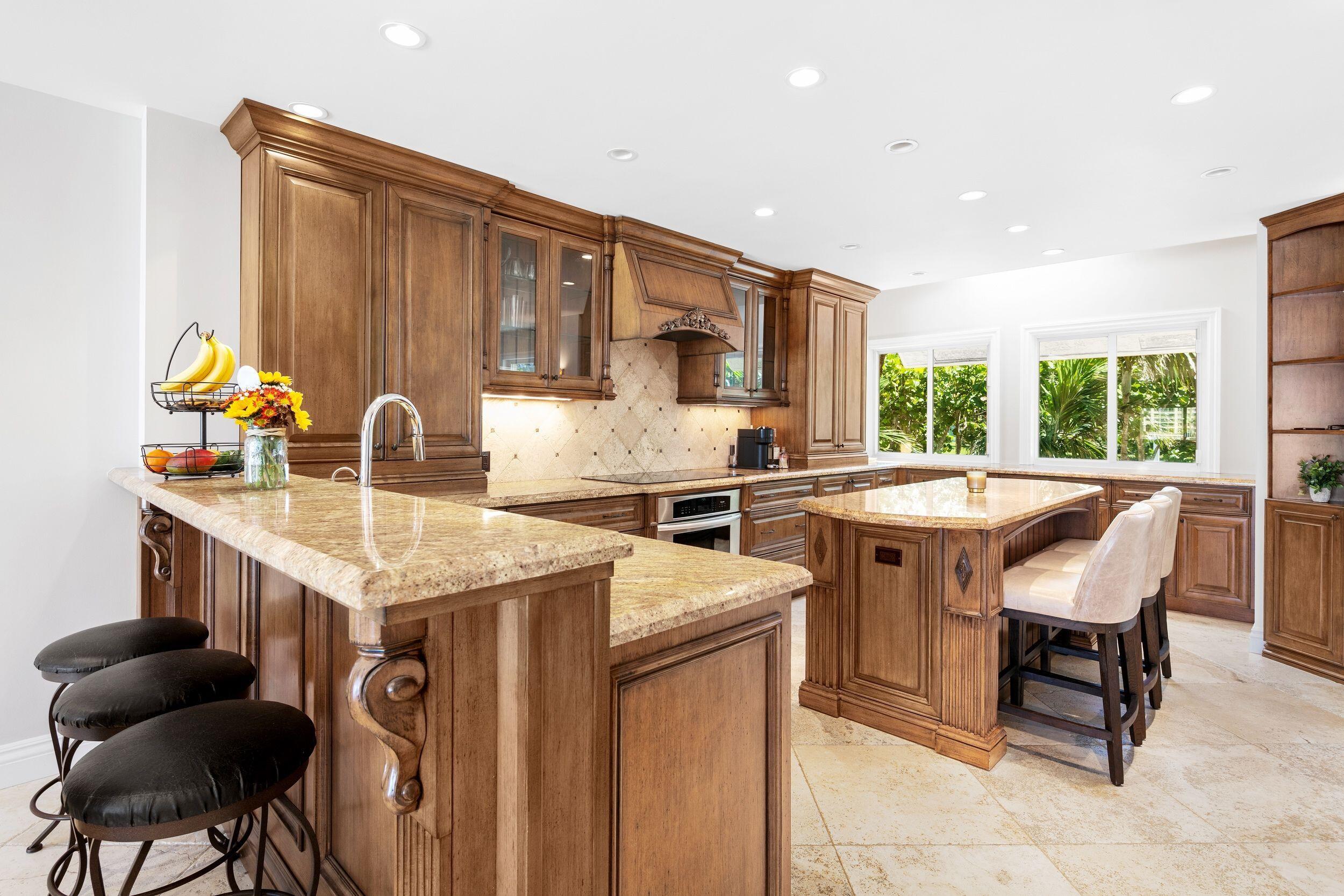 555 South Ocean Boulevard, Unit 4 Boca Raton, FL 33432 - Photo 18 of 39 a kitchen with stainless steel appliances granite countertop a table chairs and a refrigerator