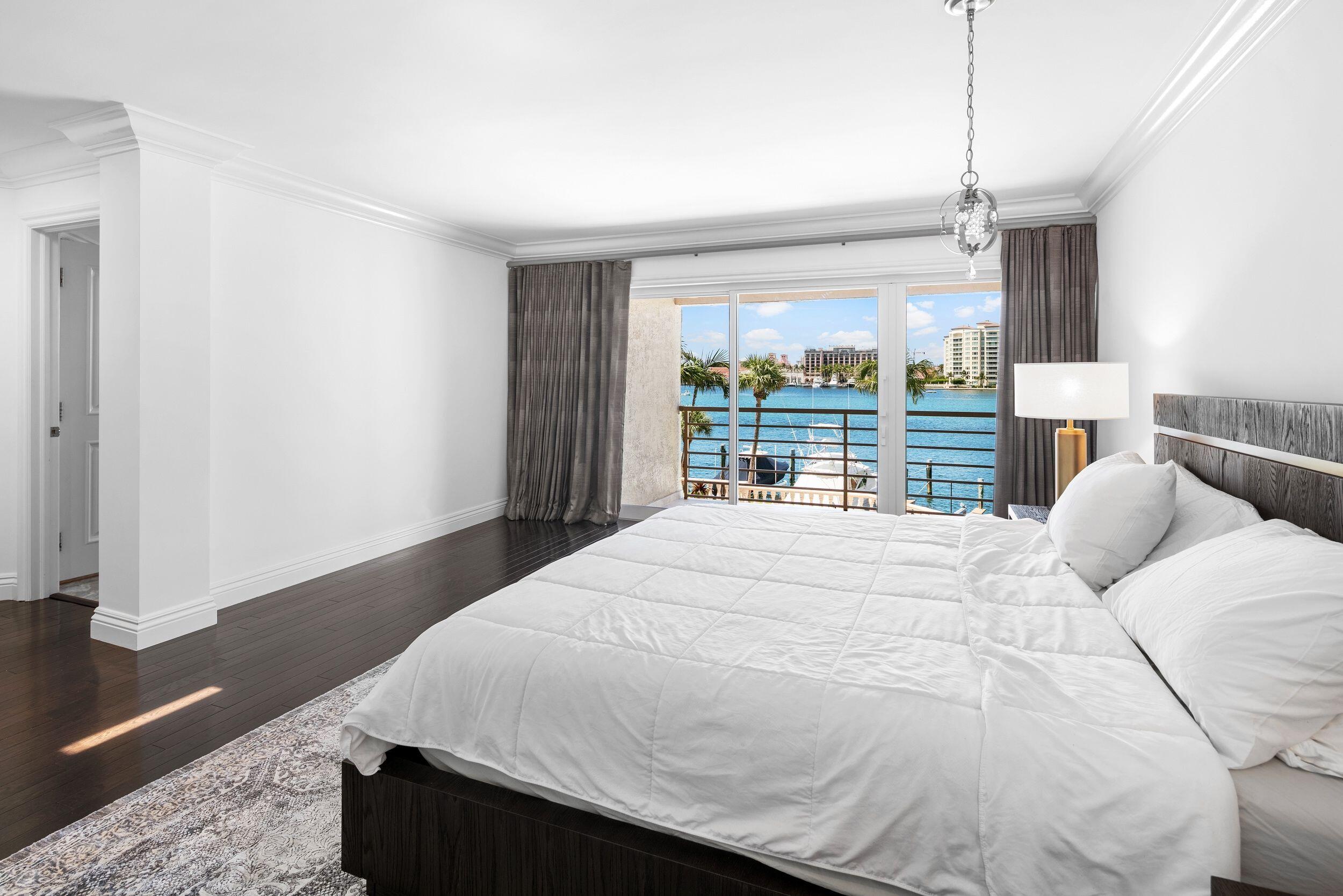 555 South Ocean Boulevard, Unit 4 Boca Raton, FL 33432 - Photo 25 of 39 a bedroom with a large bed and a large window