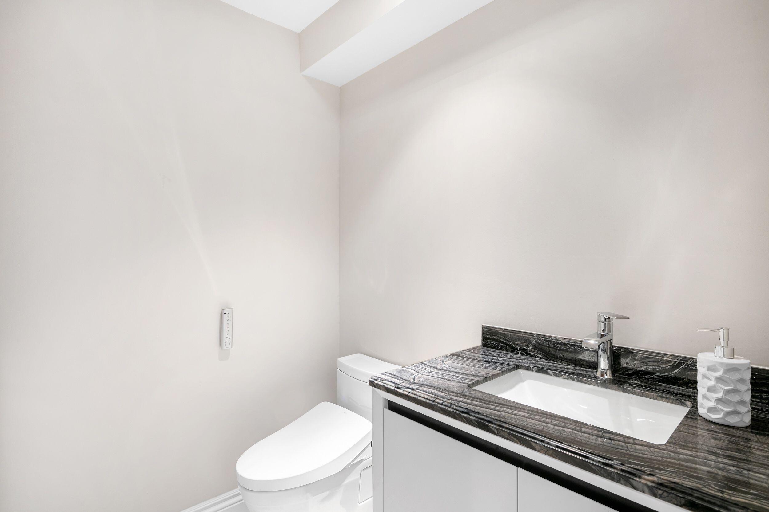 555 South Ocean Boulevard, Unit 4 Boca Raton, FL 33432 - Photo 30 of 39 a bathroom with a granite countertop toilet sink and mirror