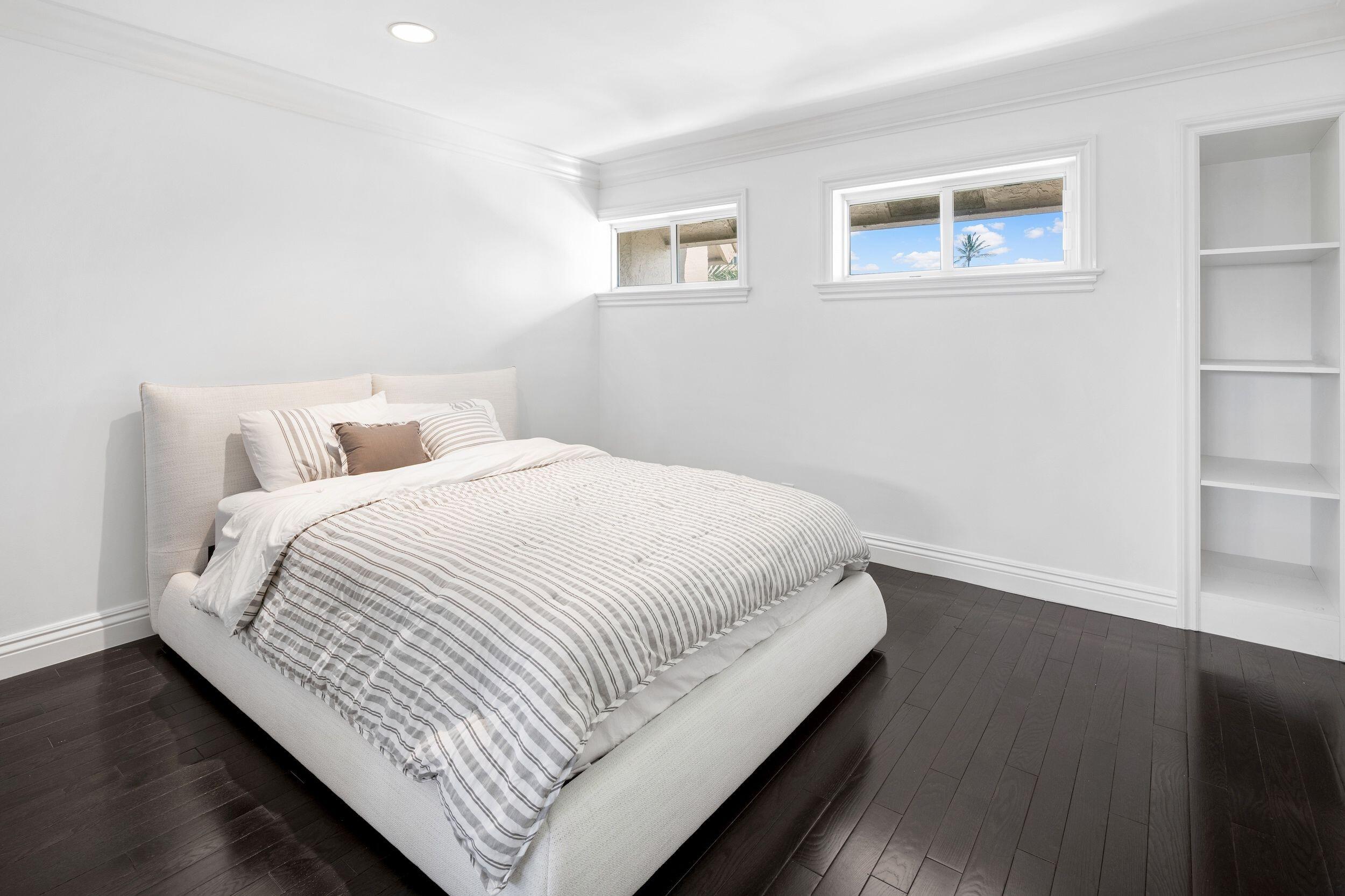 555 South Ocean Boulevard, Unit 4 Boca Raton, FL 33432 - Photo 31 of 39 a bedroom with a bed and wooden floor