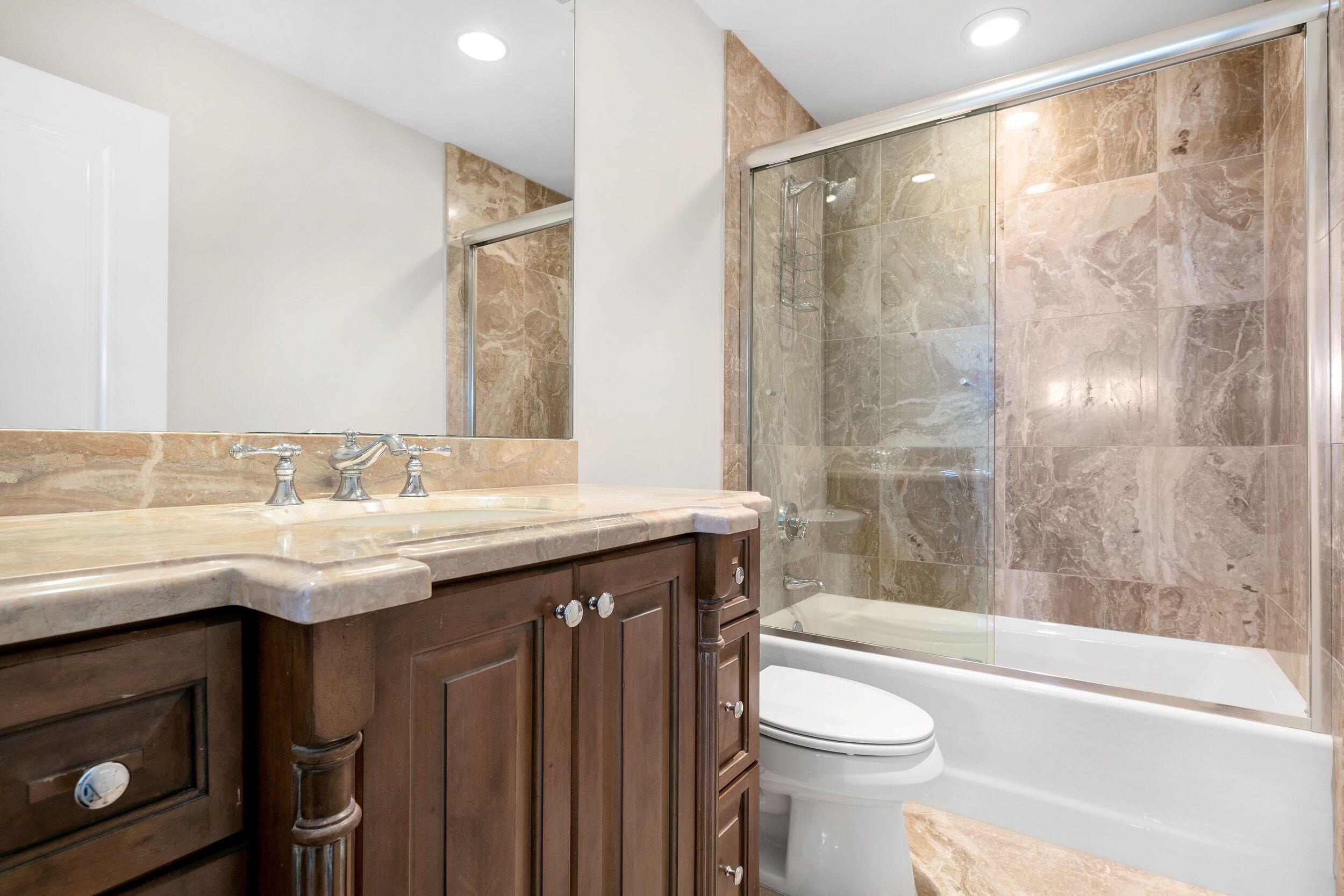 555 South Ocean Boulevard, Unit 4 Boca Raton, FL 33432 - Photo 32 of 39 a bathroom with a granite countertop sink toilet and shower