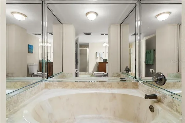 a bathroom with a tub sink and mirror