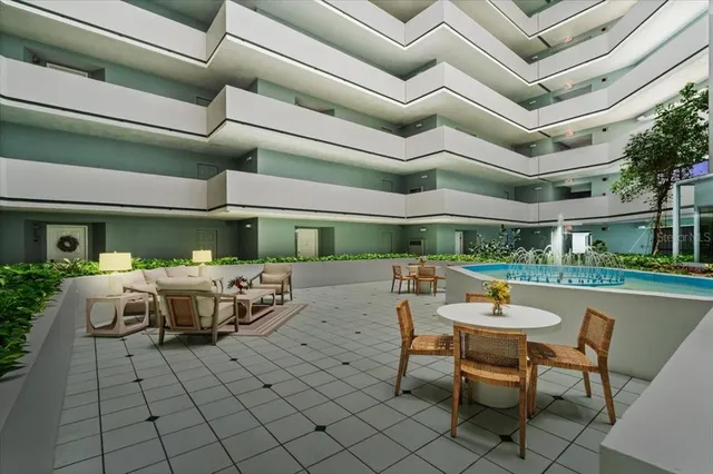 a view of a patio with table and chairs with a barbeque