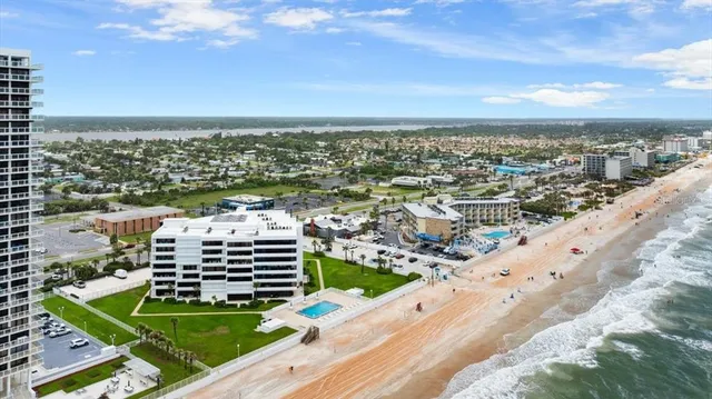 an aerial view of a residential houses with a yard and lake view