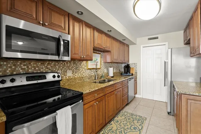 a kitchen with stainless steel appliances a stove microwave and sink