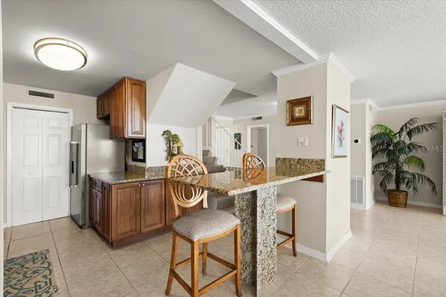 a kitchen with stainless steel appliances kitchen island granite countertop a refrigerator and microwave