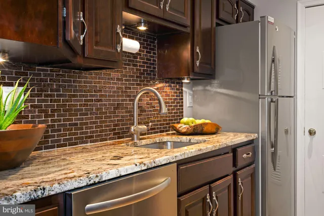 a bathroom with a granite countertop sink a toilet and shower