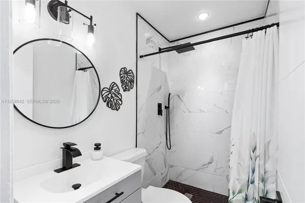 a bathroom with a sink vanity mirror and toilet