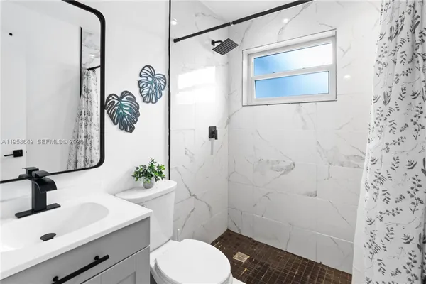 a bathroom with a sink toilet and shower