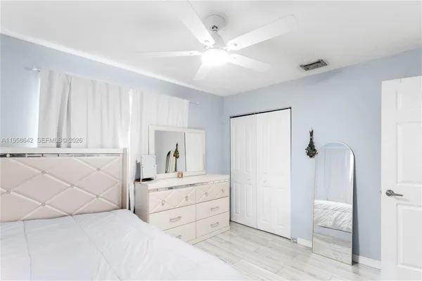 a spacious bedroom with a large bed and a chandelier