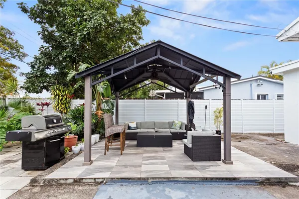 a view of a patio with table and chairs with wooden fence and plants