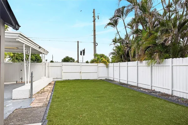 a view of a backyard with white fence