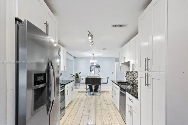 a kitchen with stainless steel appliances a refrigerator and a stove top oven