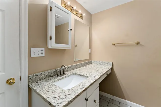 a bathroom with a granite countertop sink and a mirror