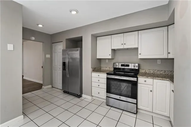 a kitchen with stainless steel appliances granite countertop a refrigerator and a stove top oven