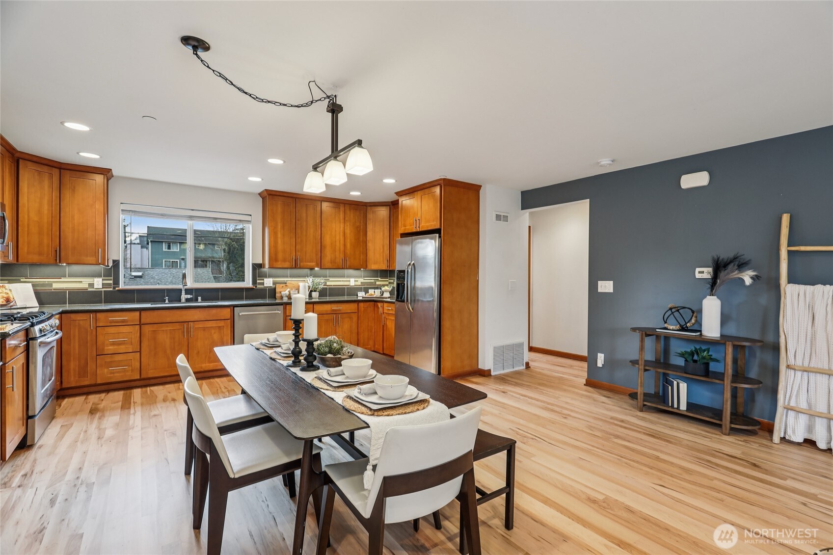 14539 32nd Avenue Northeast, Unit A Shoreline, WA 98155 - Photo 7 of 27 a kitchen with stainless steel appliances wooden floor dining table and chairs