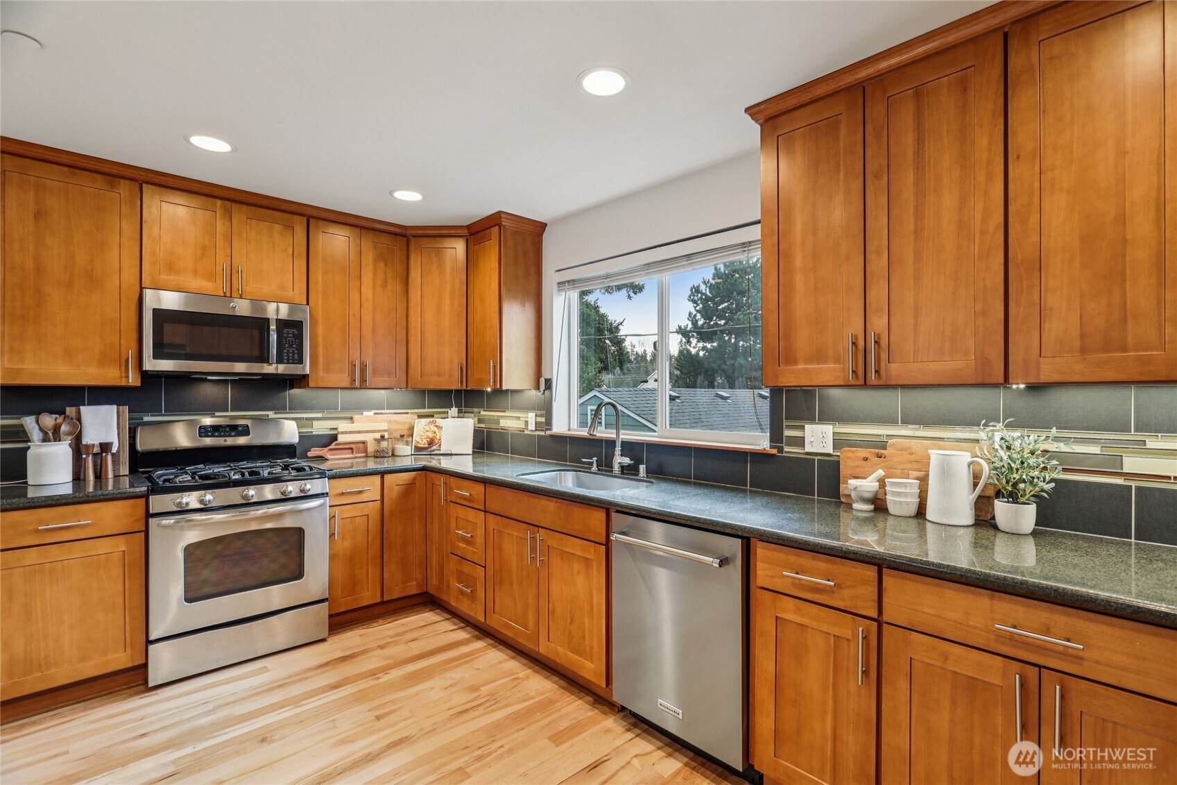 14539 32nd Avenue Northeast, Unit A Shoreline, WA 98155 - Photo 8 of 27 a kitchen with stainless steel appliances granite countertop wooden cabinets a sink a stove a window and cabinetry