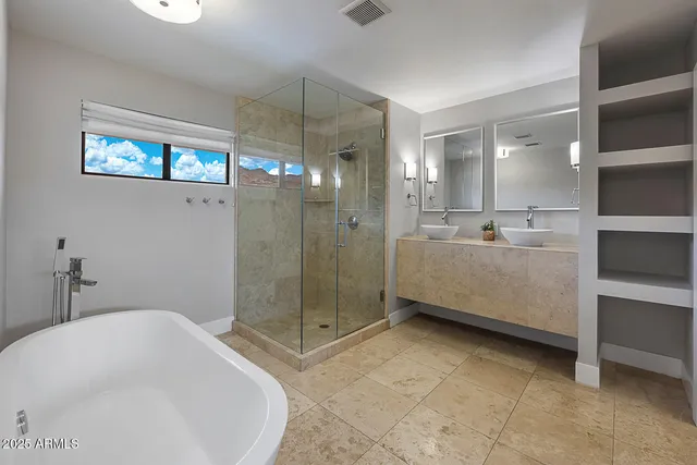 a bathroom with a bathtub a mirror and a shower
