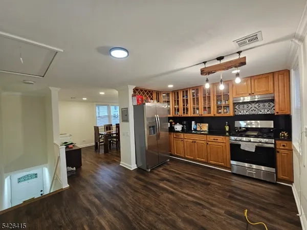 a view of a hallway with wooden floor and a bathroom