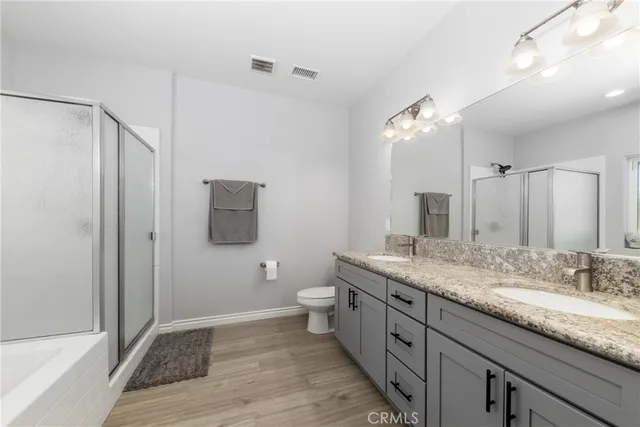 a spacious bathroom with a granite countertop sink toilet and shower