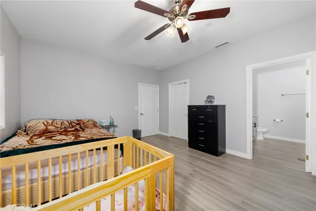 a bedroom with a bed and wooden floor