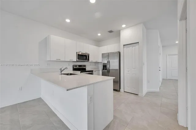 a kitchen with refrigerator and a sink