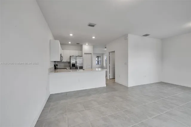 a view of kitchen with refrigerator and window