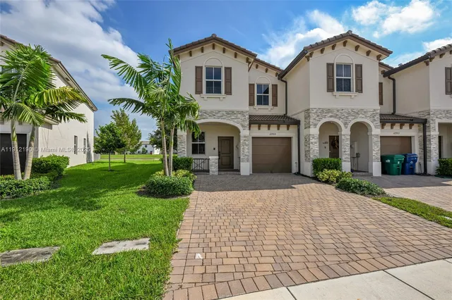 a front view of a house with a yard and a garage
