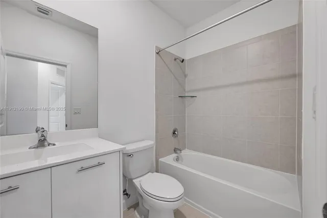 a bathroom with a granite countertop sink a toilet and shower