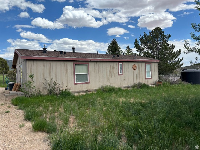 14908 North Deep Crk Road Lapoint, UT 84039 - Photo 2 of 9 Exterior features light-colored vertical siding with contrasting trim, a dark shingle roof, and multiple windows