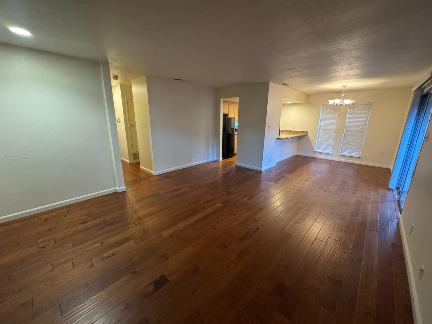 5434 Roundtree Court, Unit A Concord, CA 94521 - Photo 2 of 10 an empty room with wooden floor and windows