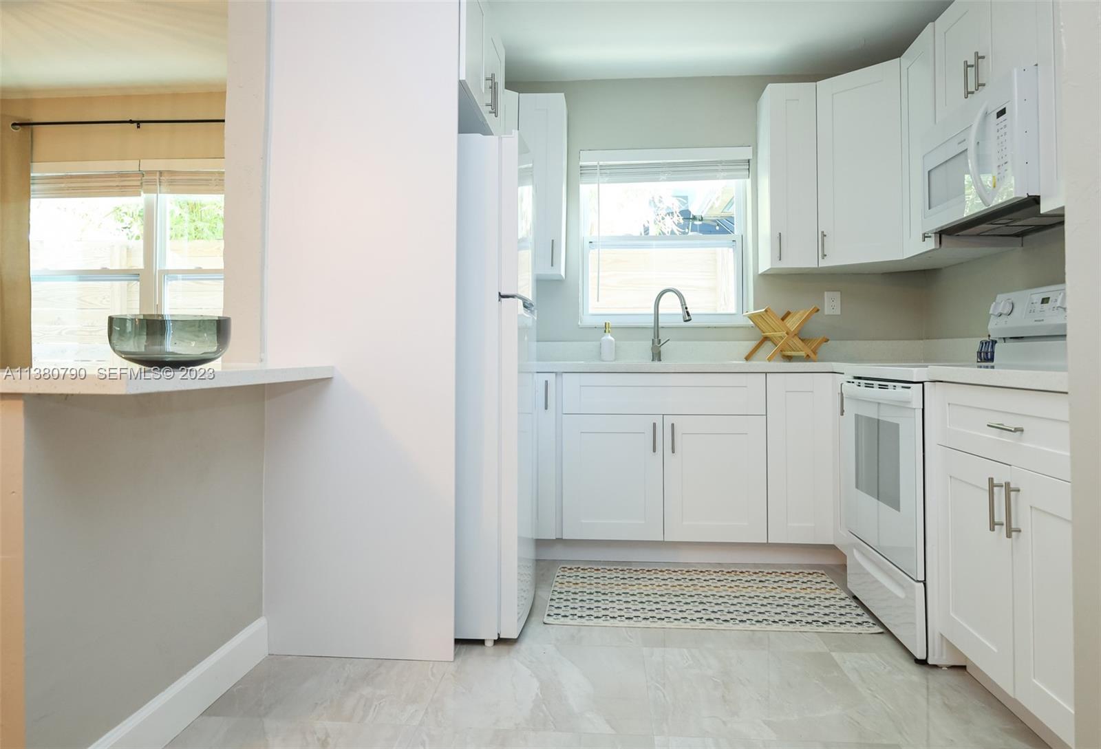 2761 Southwest 33rd Avenue, Unit 2 Miami, FL 33133 - Photo 11 of 33 a kitchen with white cabinets and window