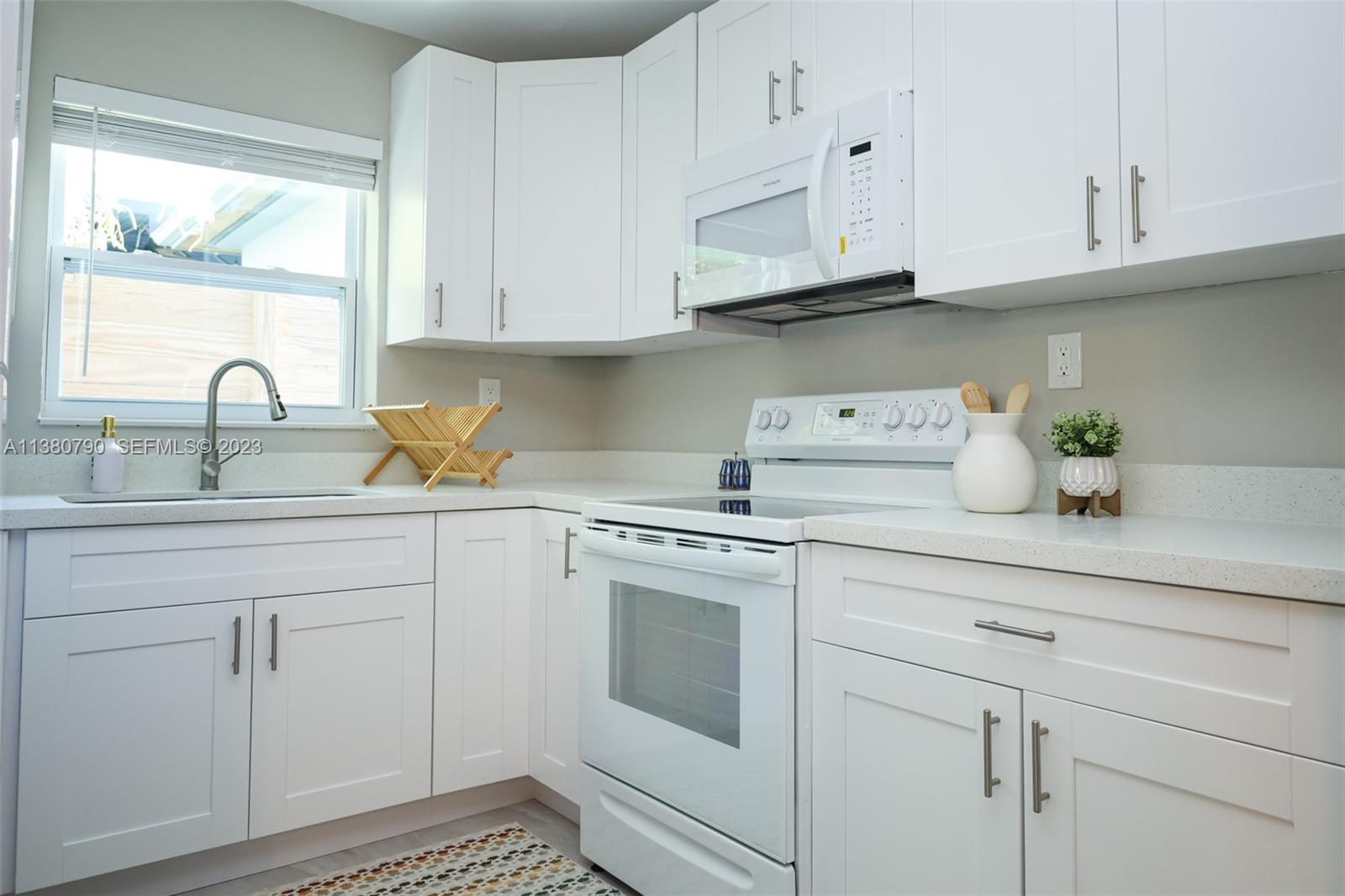 2761 Southwest 33rd Avenue, Unit 2 Miami, FL 33133 - Photo 12 of 33 a kitchen with white cabinets and white appliances