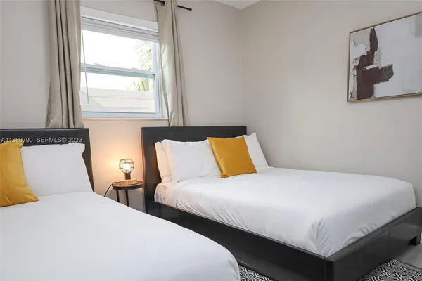 a bedroom with two beds and a window