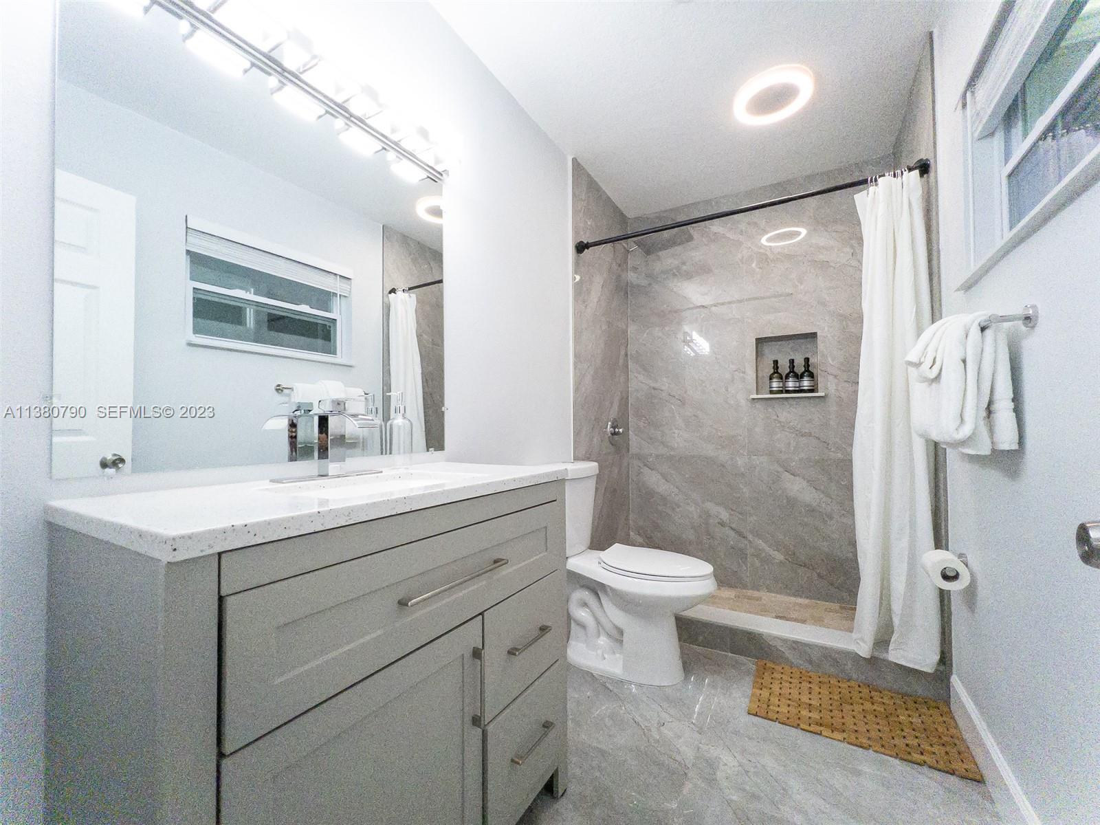 2761 Southwest 33rd Avenue, Unit 2 Miami, FL 33133 - Photo 22 of 33 a bathroom with a sink a toilet a mirror and shower