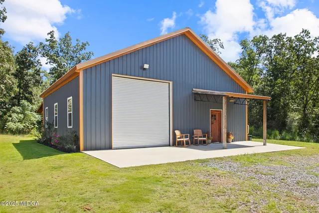 a view of a house with backyard and trees