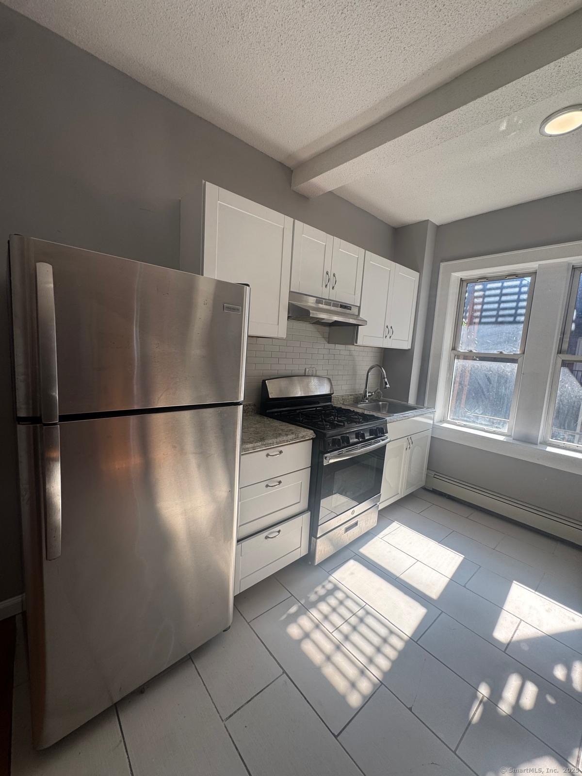 a kitchen with stainless steel appliances granite countertop a refrigerator sink and stove