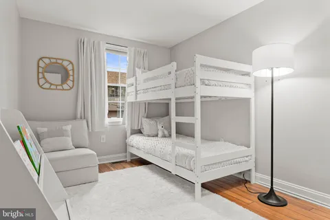 a view of a bedroom with bed and wooden floor