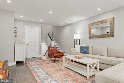 a living room with furniture and wooden floor