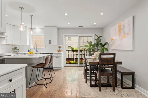 a kitchen with white cabinets and sink