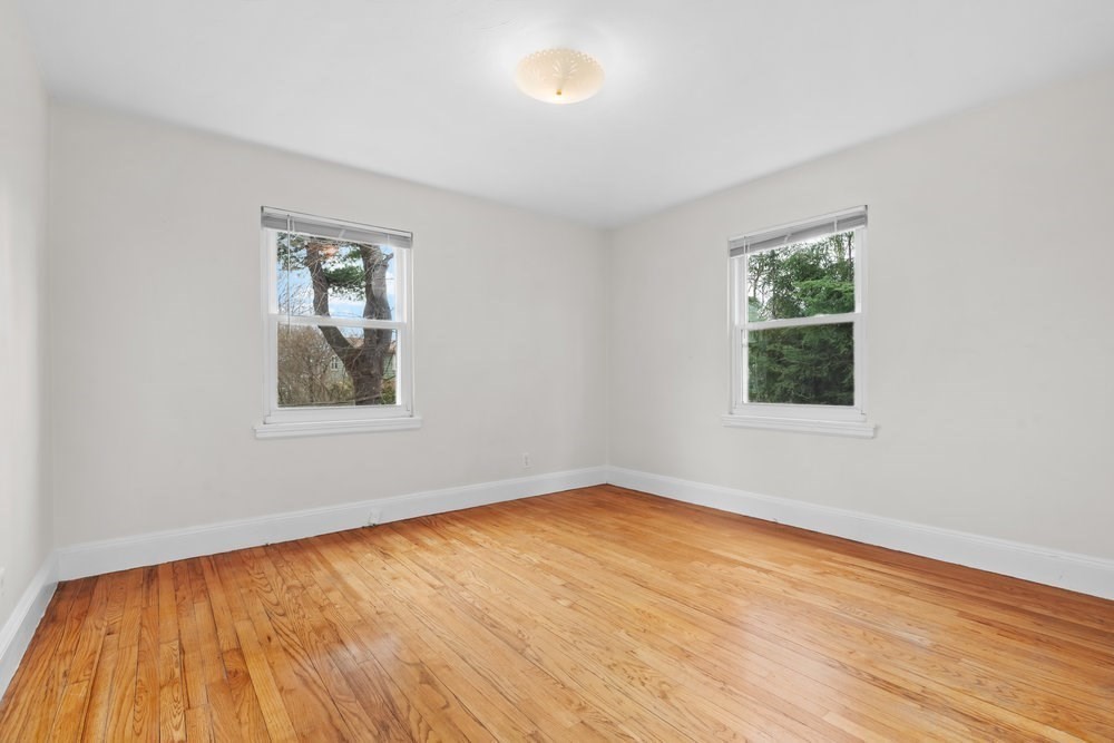 12 Pershing Road Newton, MA 02465 - Photo 16 of 29 a view of an empty room with wooden floor and a window