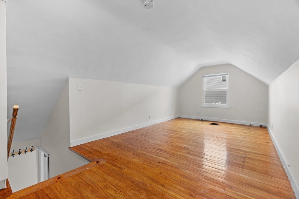 12 Pershing Road Newton, MA 02465 - Photo 19 of 29 a view of an empty room with wooden floor and a window
