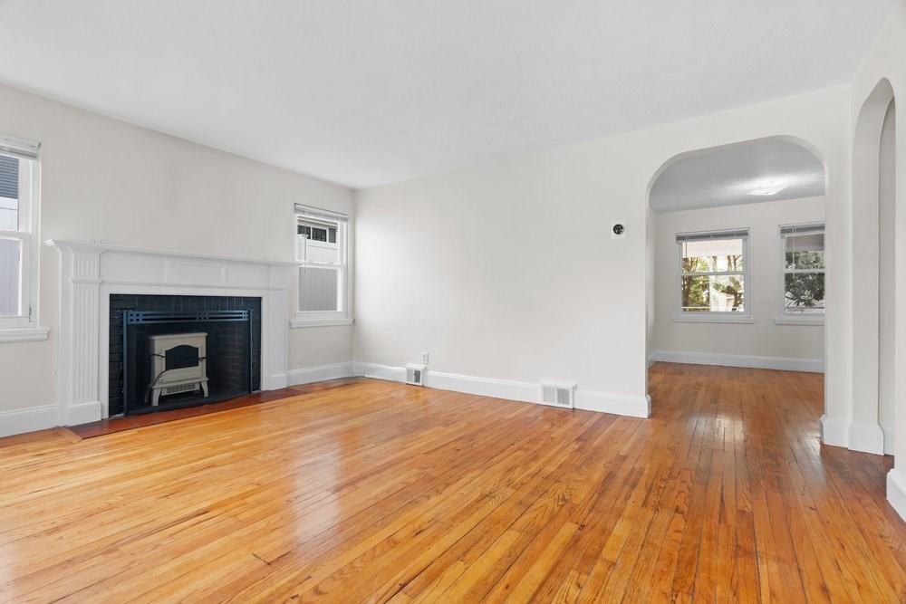 12 Pershing Road Newton, MA 02465 - Photo 3 of 29 a view of empty room with wooden floor and fireplace