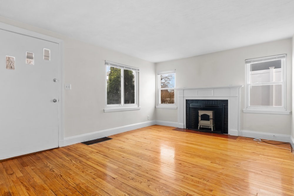 12 Pershing Road Newton, MA 02465 - Photo 4 of 29 a view of an empty room with wooden floor and a window