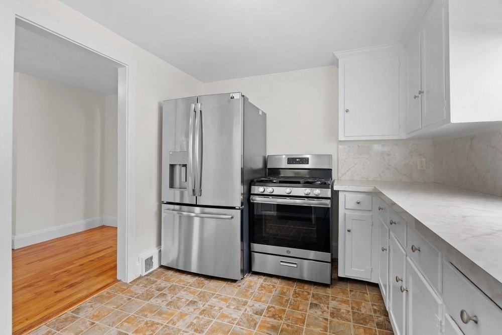 12 Pershing Road Newton, MA 02465 - Photo 10 of 29 a kitchen with stainless steel appliances granite countertop a refrigerator sink and stove
