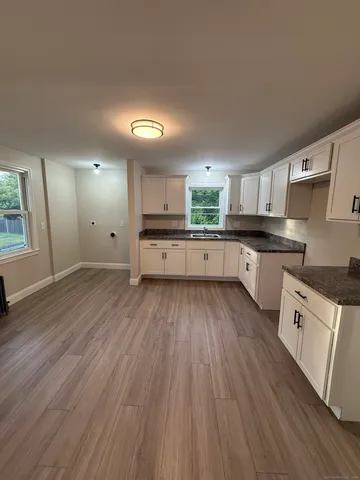 a large kitchen with cabinets wooden floor and stainless steel appliances