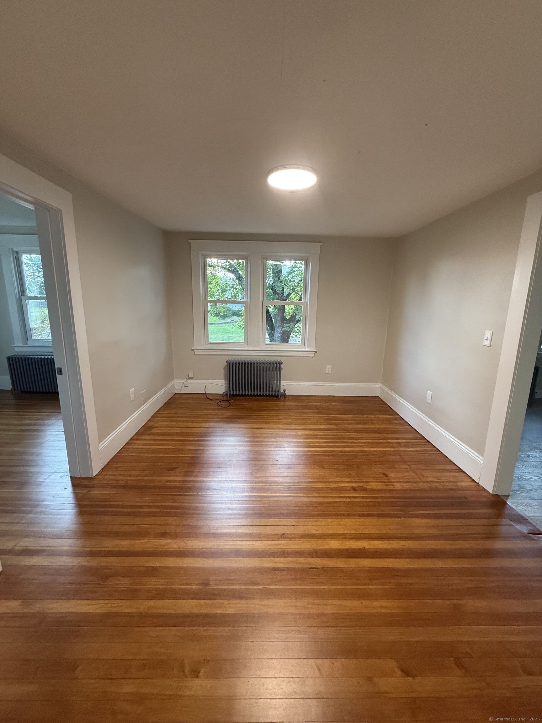 820 Burbank Avenue Suffield, CT 06078 - Photo 7 of 15 an empty room with wooden floor and windows