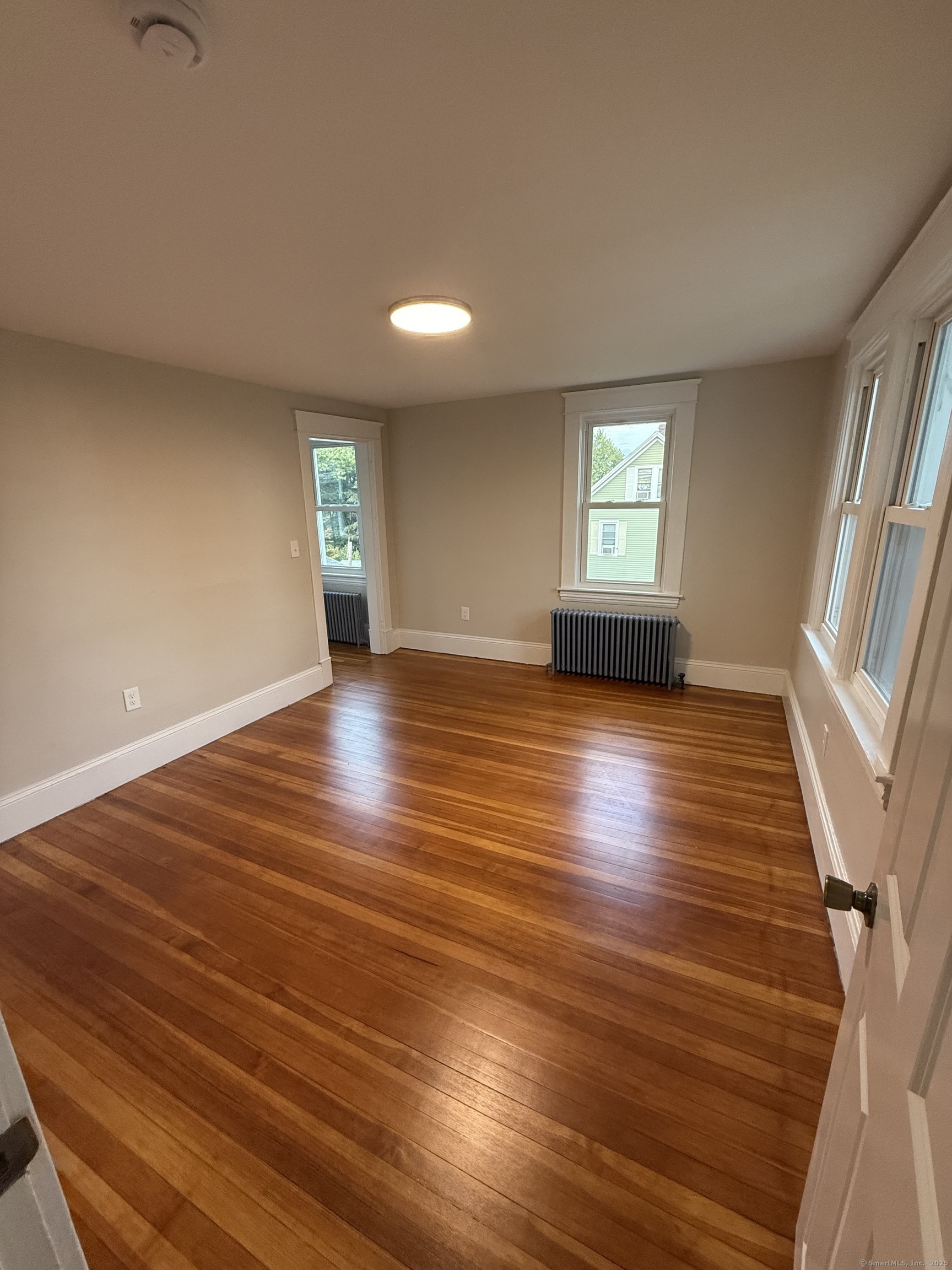 820 Burbank Avenue Suffield, CT 06078 - Photo 10 of 15 an empty room with wooden floor and windows