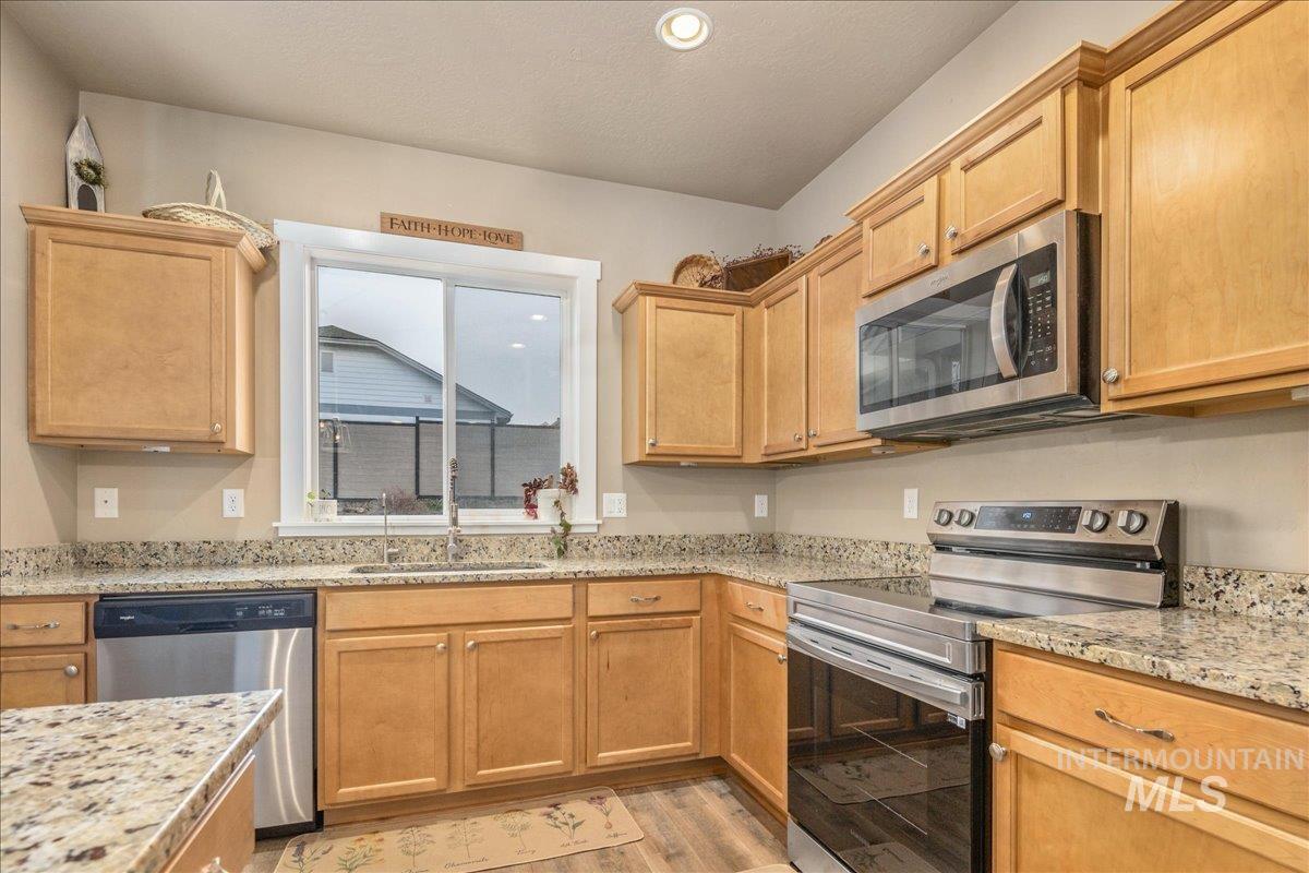5668 West Old Ranch Street Boise, ID 83714 - Photo 12 of 44 Kitchen with stainless steel appliances, light stone counters, light wood-type flooring, and recessed lighting