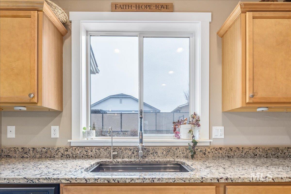 5668 West Old Ranch Street Boise, ID 83714 - Photo 14 of 44 Kitchen with light stone countertops and light brown cabinetry